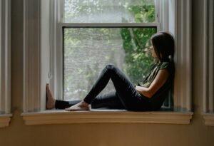 Woman sitting by a window in quiet reflection
